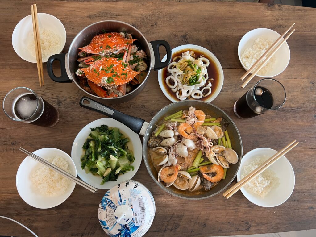 Mesa com diversos pratos de frutos do mar servidos em uma refeição chinesa compartilhada