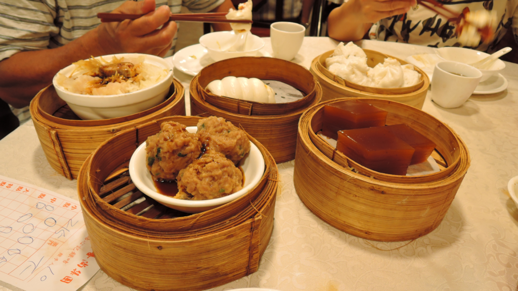 Diversos pratos de dim sum servidos em cestos de bambu